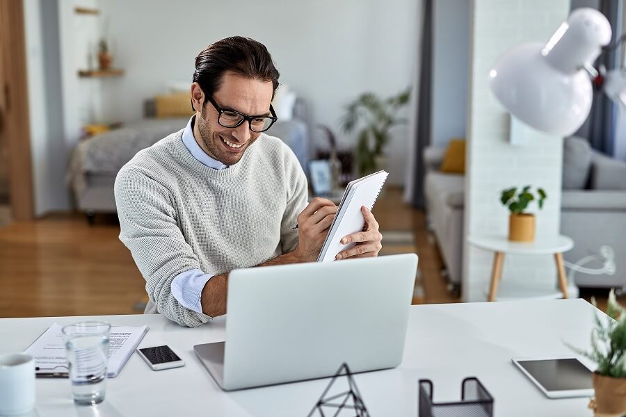 Young happy guy working home holding his head pain while facing error